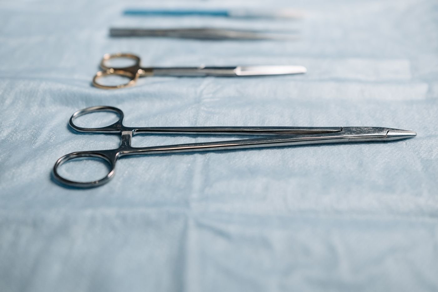 A surgical needle holder and scissors laid out for inspection