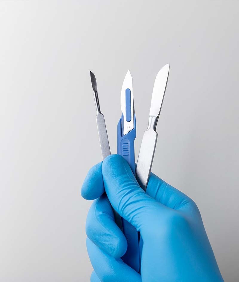 Scalpels held in a gloved hand